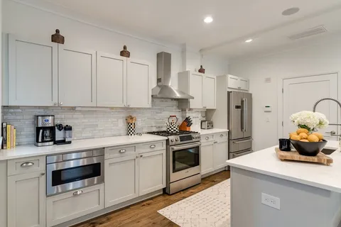 a kitchen with stainless steel appliances granite countertop a sink a stove and refrigerator