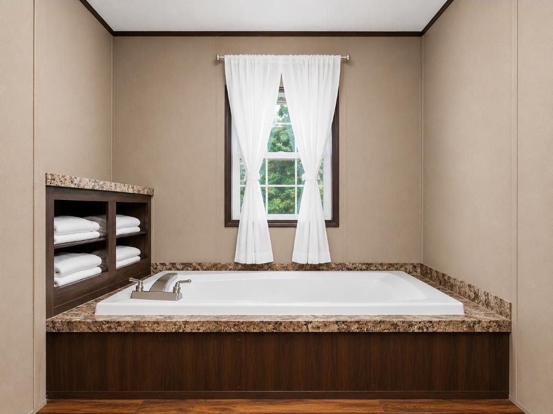 3779 Dancyville Road Stanton, TN 38069 - Photo 17 of 22 Built-in soaking tub with stone-finish surround, rich wood-finish paneling, and brushed nickel fixtures