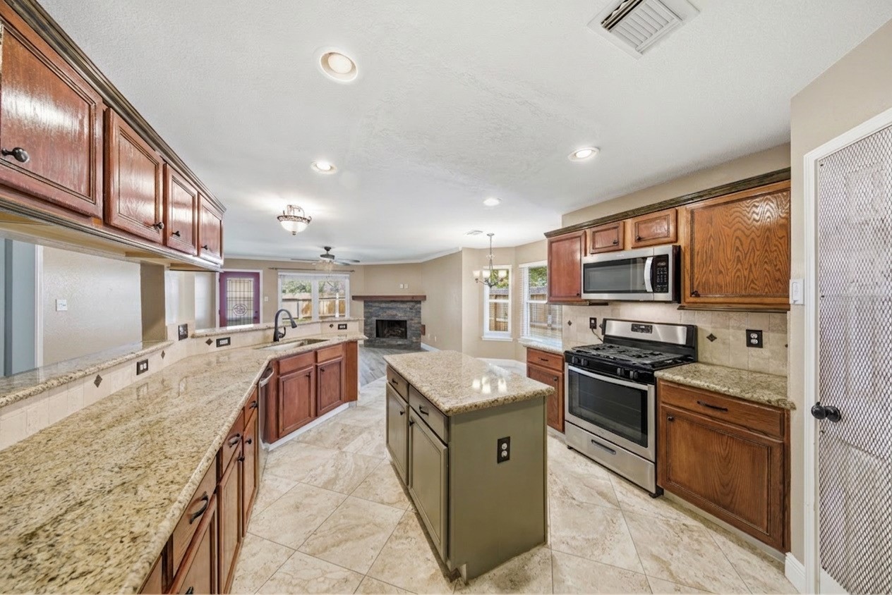 13506 Spring Court Tomball, TX 77375 - Photo 11 of 37 a large kitchen with stainless steel appliances granite countertop a stove refrigerator and a sink