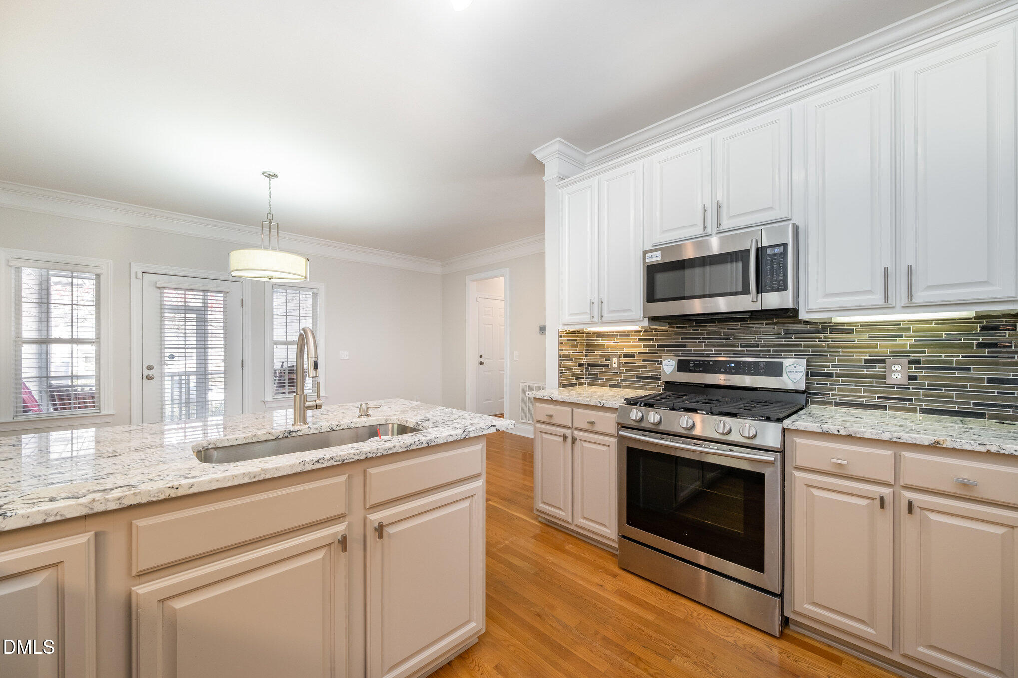 3912 Stags Leap Circle, Unit 27 Raleigh, NC 27612 - Photo 2 of 28 a kitchen with kitchen island granite countertop white cabinets white stainless steel appliances and a sink