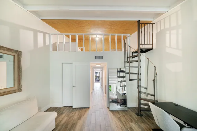 a view of a hallway with wooden floor and staircase