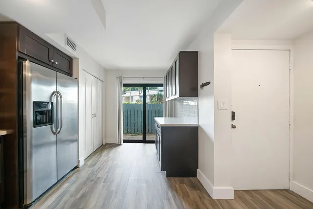 a kitchen with stainless steel appliances a refrigerator and wooden floor