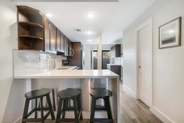 a kitchen with kitchen island cabinets and wooden floor