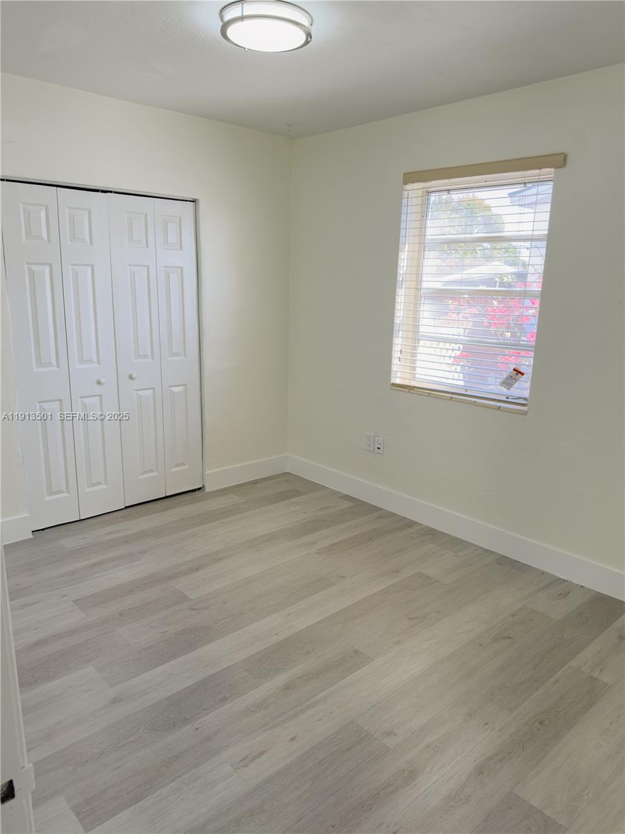 467 Southeast 3rd Street, Unit 1 Hialeah, FL 33010 - Photo 14 of 17 an empty room with wooden floor and windows