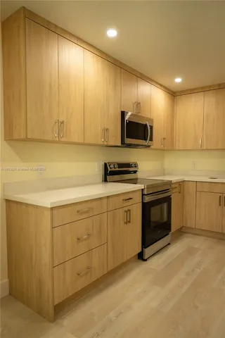 a kitchen with stainless steel appliances granite countertop a stove a sink and a microwave