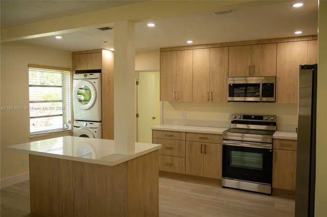 a kitchen with kitchen island granite countertop a stove and a sink