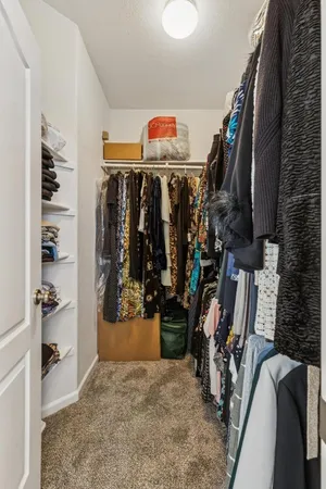a view of walk in closet with clothes and shoes