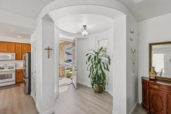 a view of a hallway view with wooden floor and a living room