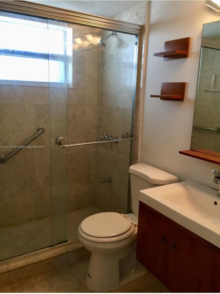 1300 Lincoln Road, Unit B302 Miami Beach, FL 33139 - Photo 5 of 14 a bathroom with a sink a toilet and shower