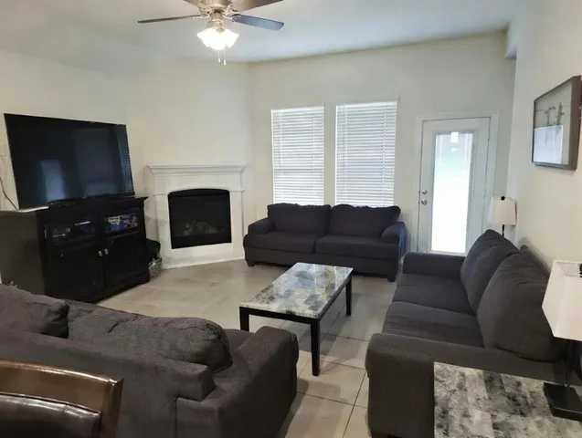 a living room with furniture a fireplace and a flat screen tv