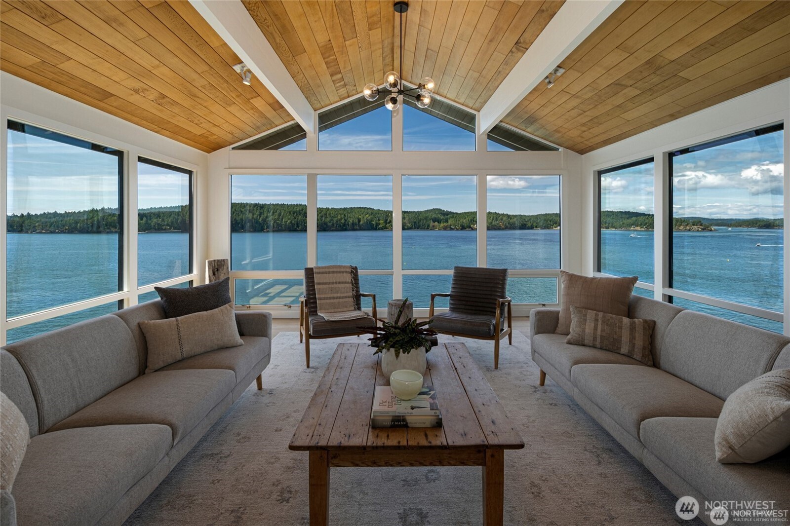 a living room with furniture and floor to ceiling windows