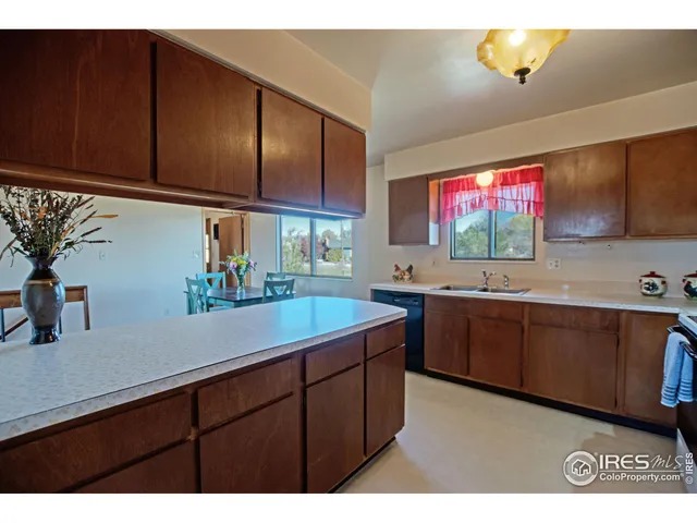 a kitchen with stainless steel appliances a sink dishwasher and cabinets with wooden floor