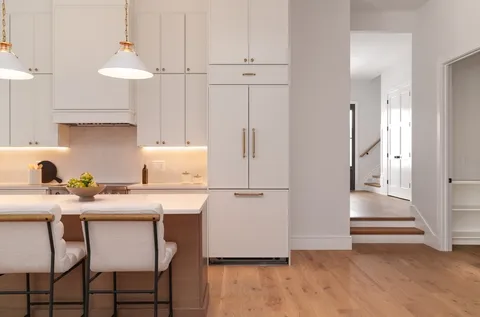 a kitchen with granite countertop a table chairs stove and cabinets
