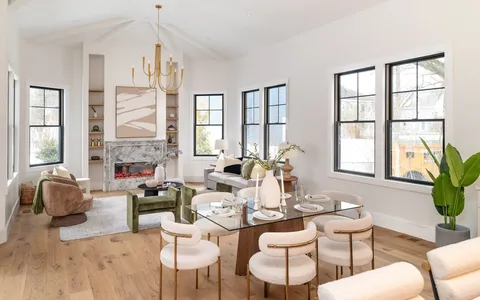a living room with fireplace furniture and a large window