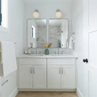 a bathroom with double vanity sinks and a mirror