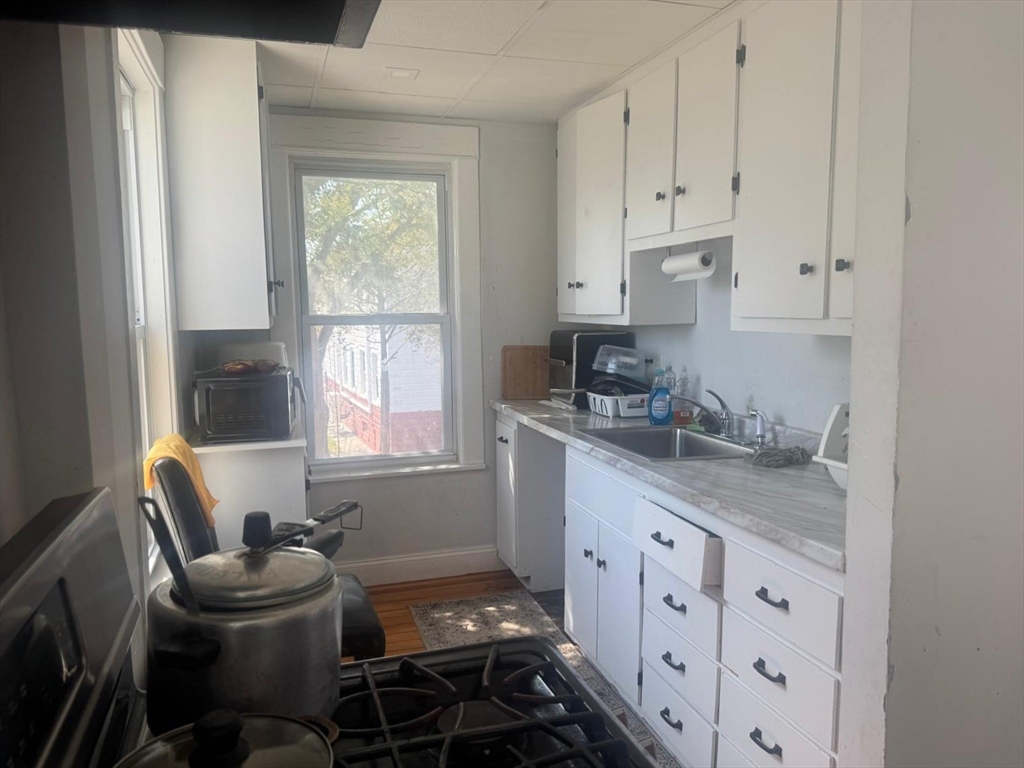 85 Seneca Street Lowell, MA 01852 - Photo 11 of 16 a kitchen with cabinets appliances and a window