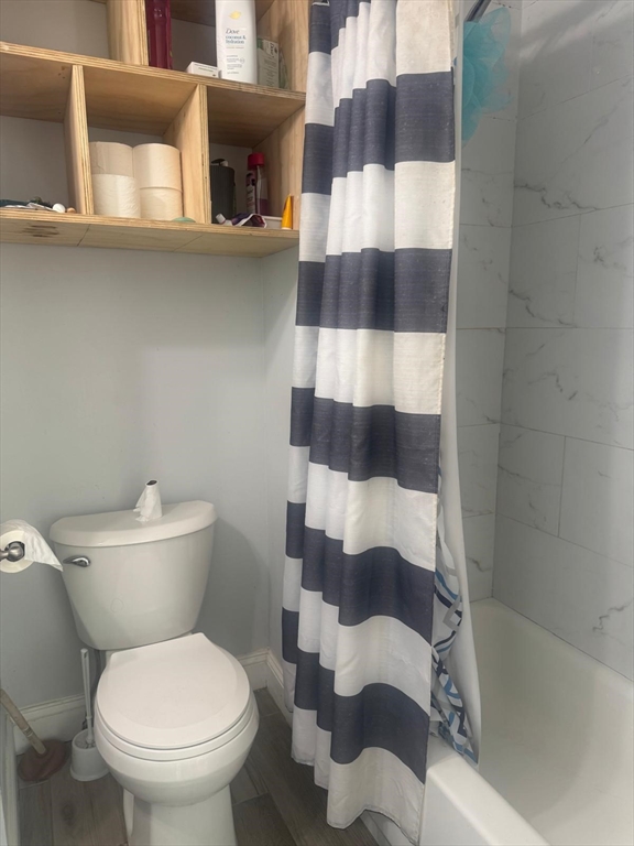 85 Seneca Street Lowell, MA 01852 - Photo 12 of 16 a white toilet sitting next to a bathroom sink and vanity
