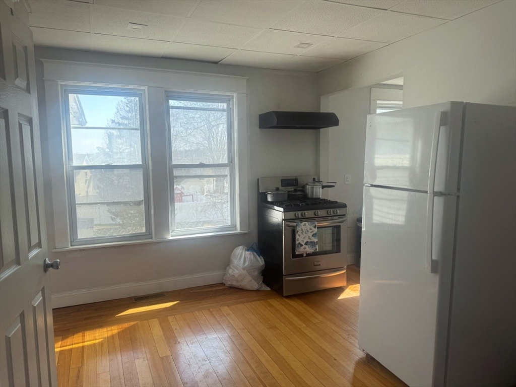 85 Seneca Street Lowell, MA 01852 - Photo 10 of 16 a kitchen with a refrigerator and a stove top oven