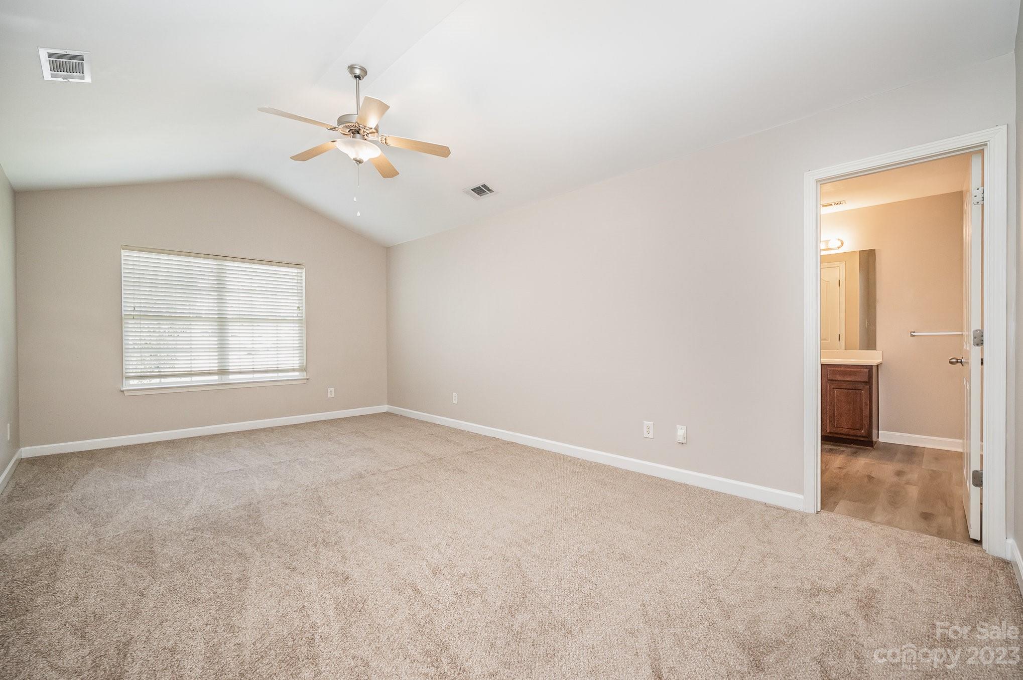 1400 Key Ridge Court Charlotte, NC 28216 - Photo 21 of 27 an empty room with windows and chandelier fan