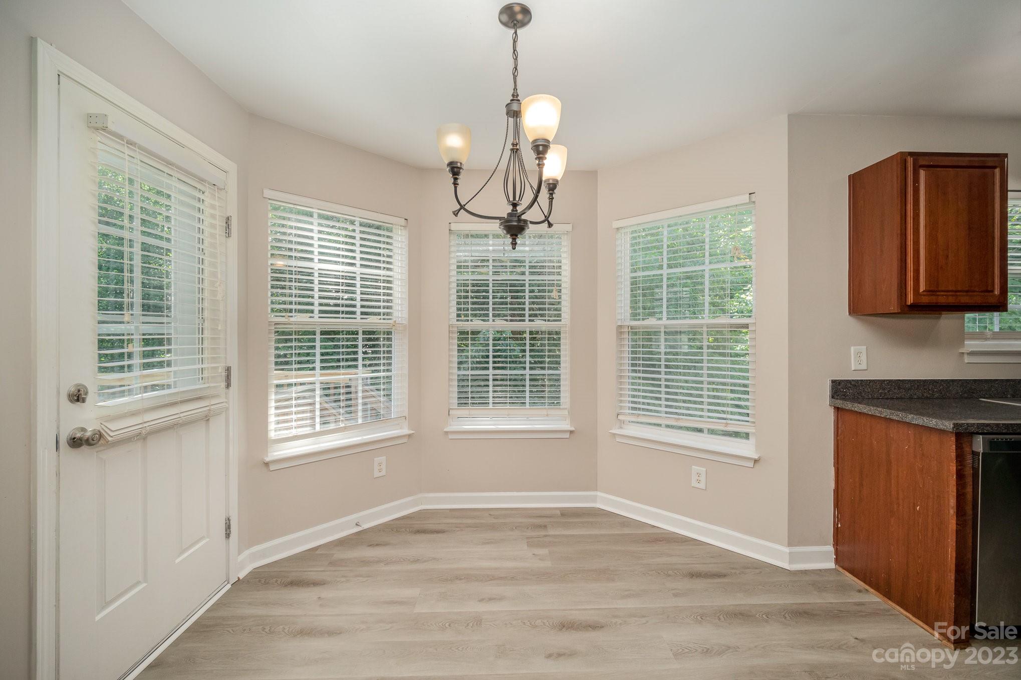 1400 Key Ridge Court Charlotte, NC 28216 - Photo 7 of 27 a view of an empty room with a window and wooden floor