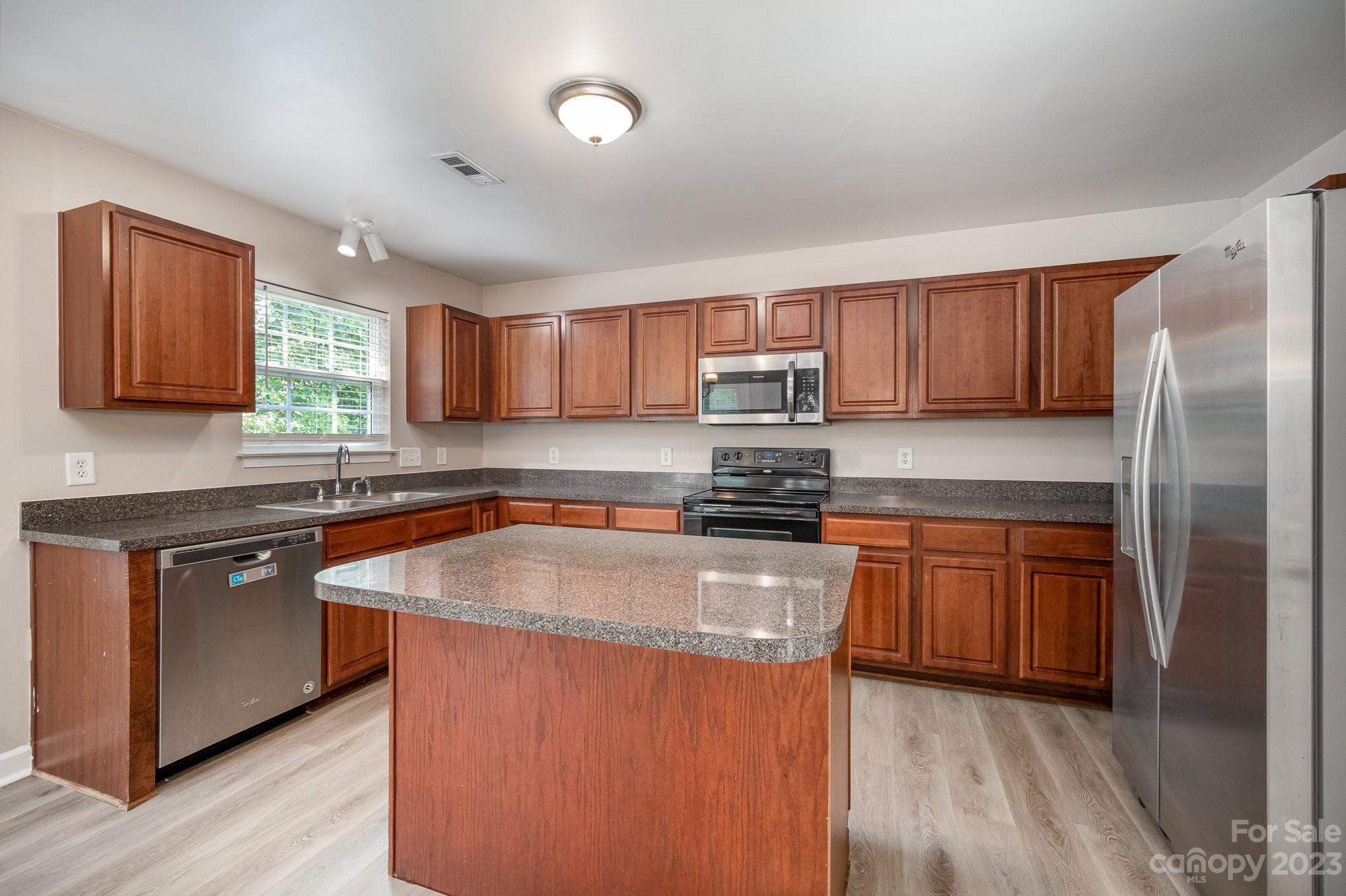 1400 Key Ridge Court Charlotte, NC 28216 - Photo 8 of 27 a kitchen with stainless steel appliances granite countertop a stove a sink dishwasher a refrigerator and a microwave oven with wooden cabinets