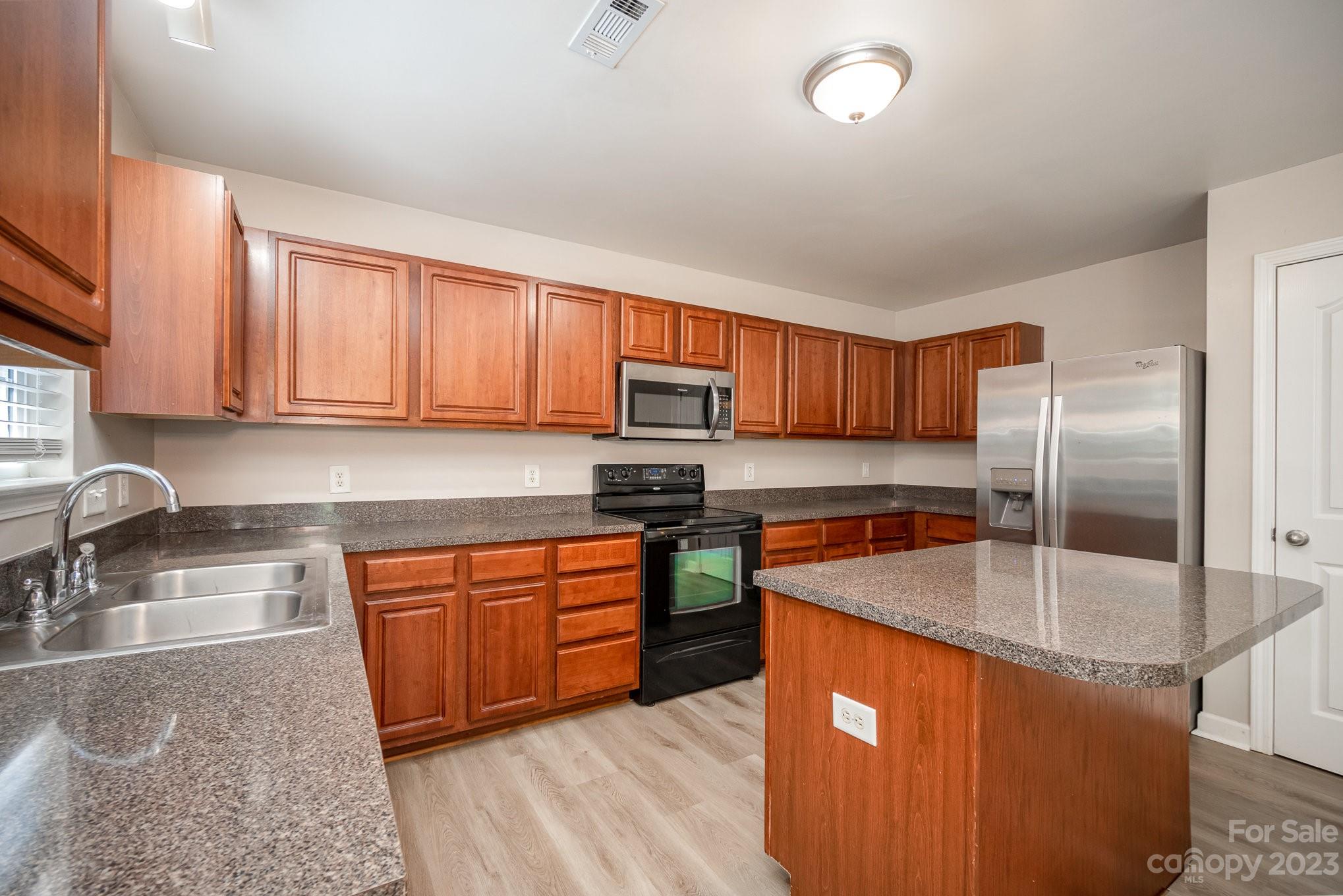 1400 Key Ridge Court Charlotte, NC 28216 - Photo 10 of 27 a kitchen with stainless steel appliances granite countertop a sink stove and refrigerator