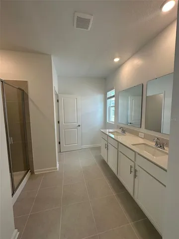 a large bathroom with a double vanity sink and mirror