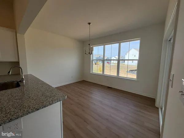 a view of a kitchen with a sink wooden floor and a window