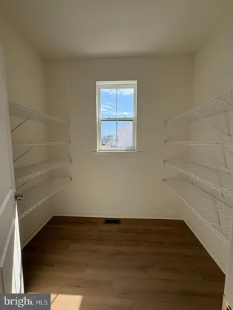 a view of a small space with wooden floor and a window