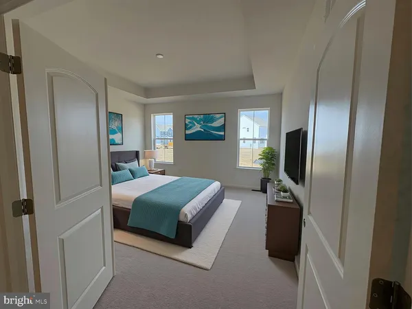 a bedroom with a bed flat screen tv and a window