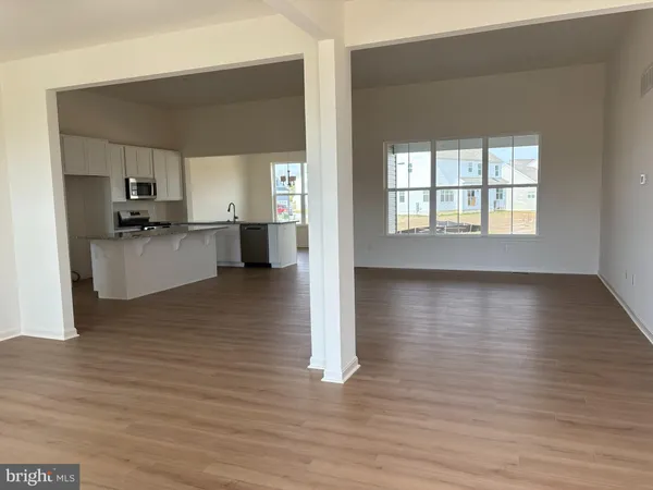 a view of a kitchen with kitchen island a sink wooden floor and a counter top space