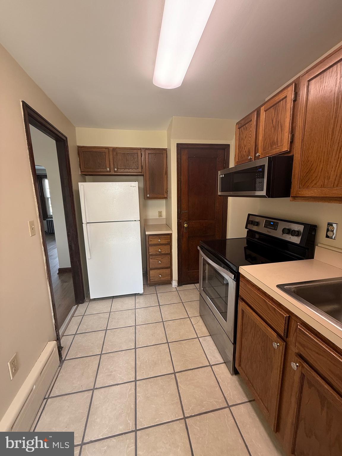 224 Pershing Boulevard Reading, PA 19607 - Photo 8 of 24 a kitchen with a sink a refrigerator and cabinets
