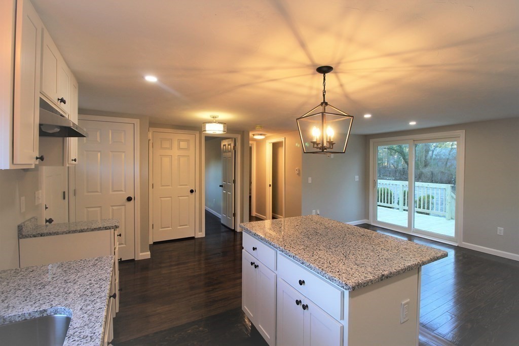 61 Chipaway Road Freetown, MA 02717 - Photo 15 of 27 a kitchen with kitchen island granite countertop wooden floor and a chandelier