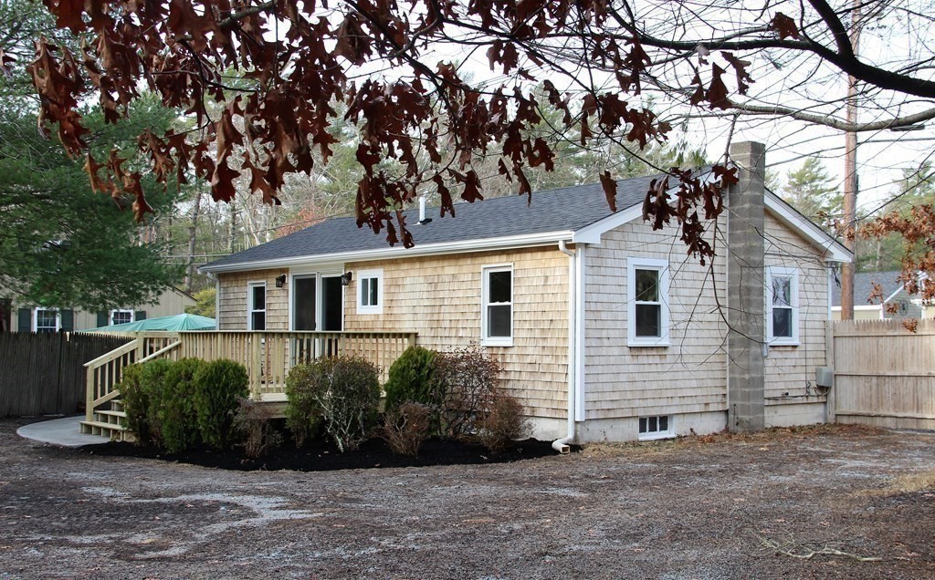 61 Chipaway Road Freetown, MA 02717 - Photo 19 of 27 a view of a white house next to a yard and a large tree