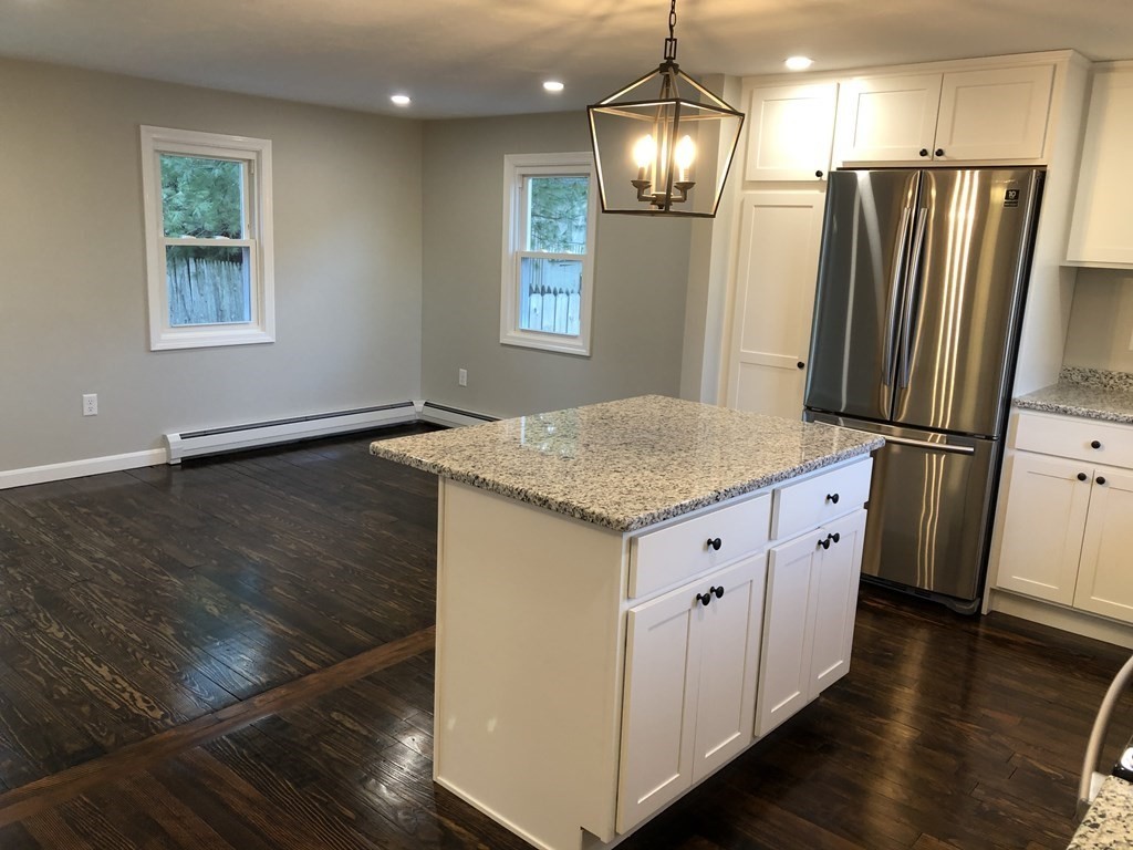 61 Chipaway Road Freetown, MA 02717 - Photo 7 of 27 a kitchen with granite countertop a refrigerator a sink dishwasher a stove and white countertops with wooden floor