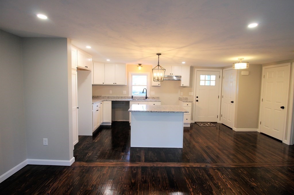 61 Chipaway Road Freetown, MA 02717 - Photo 8 of 27 a kitchen with kitchen island granite countertop a sink cabinets and wooden floor