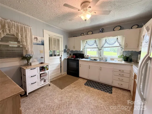 a kitchen with white cabinets and window