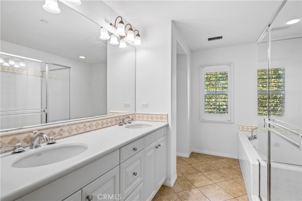 61 Bellwind Irvine, CA 92603 - Photo 12 of 23 a spacious bathroom with a granite countertop sink a large mirror and a shower