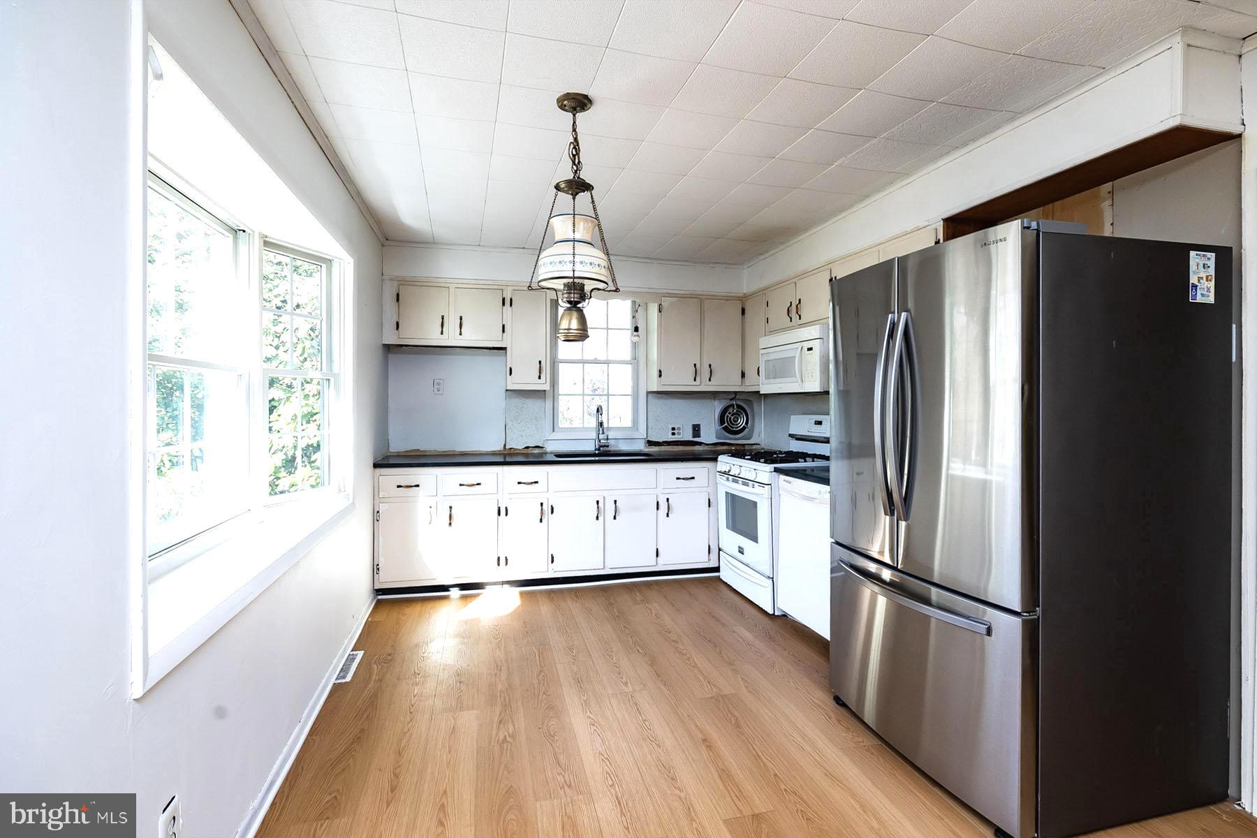 1520 Chestnut Avenue Haddon Heights, NJ 08035 - Photo 13 of 33 a kitchen with stainless steel appliances a refrigerator a sink dishwasher a stove and white cabinets with wooden floor