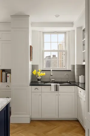 a kitchen with granite countertop a sink and white cabinets