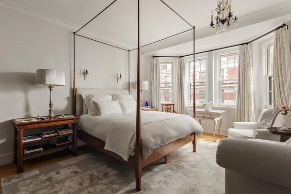 a bedroom with a bed couch and a large window