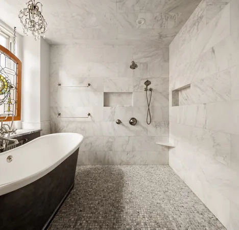 a bathroom with a tub sink shower and two mirror