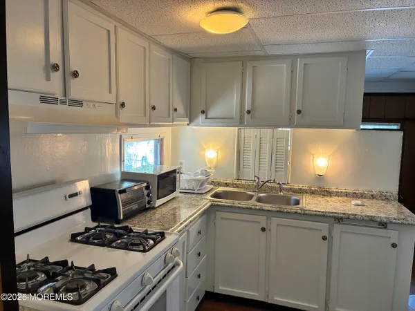 a kitchen with stainless steel appliances granite countertop a sink stove and cabinets
