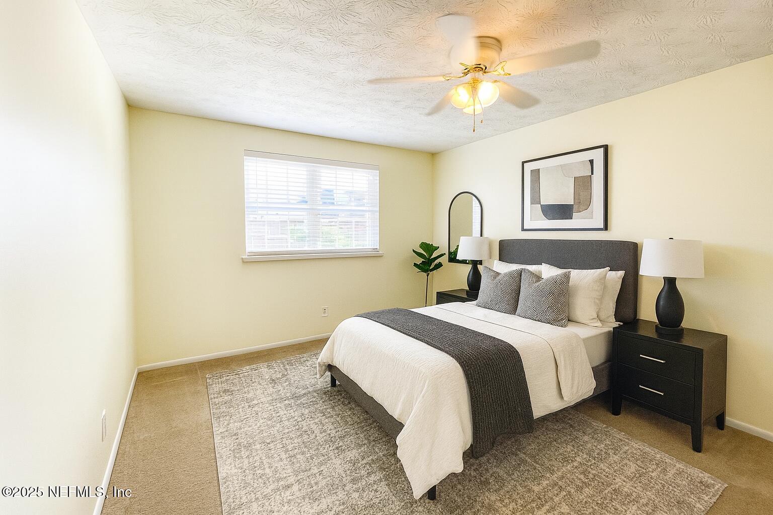 4915 Baymeadows Road, Unit 13D Jacksonville, FL 32217 - Photo 11 of 23 a spacious bedroom with a bed and a chandelier