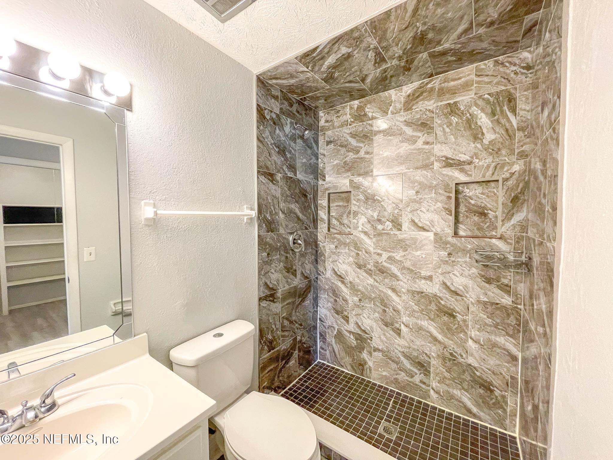 4915 Baymeadows Road, Unit 13D Jacksonville, FL 32217 - Photo 17 of 23 a white toilet sitting next to a bathroom sink