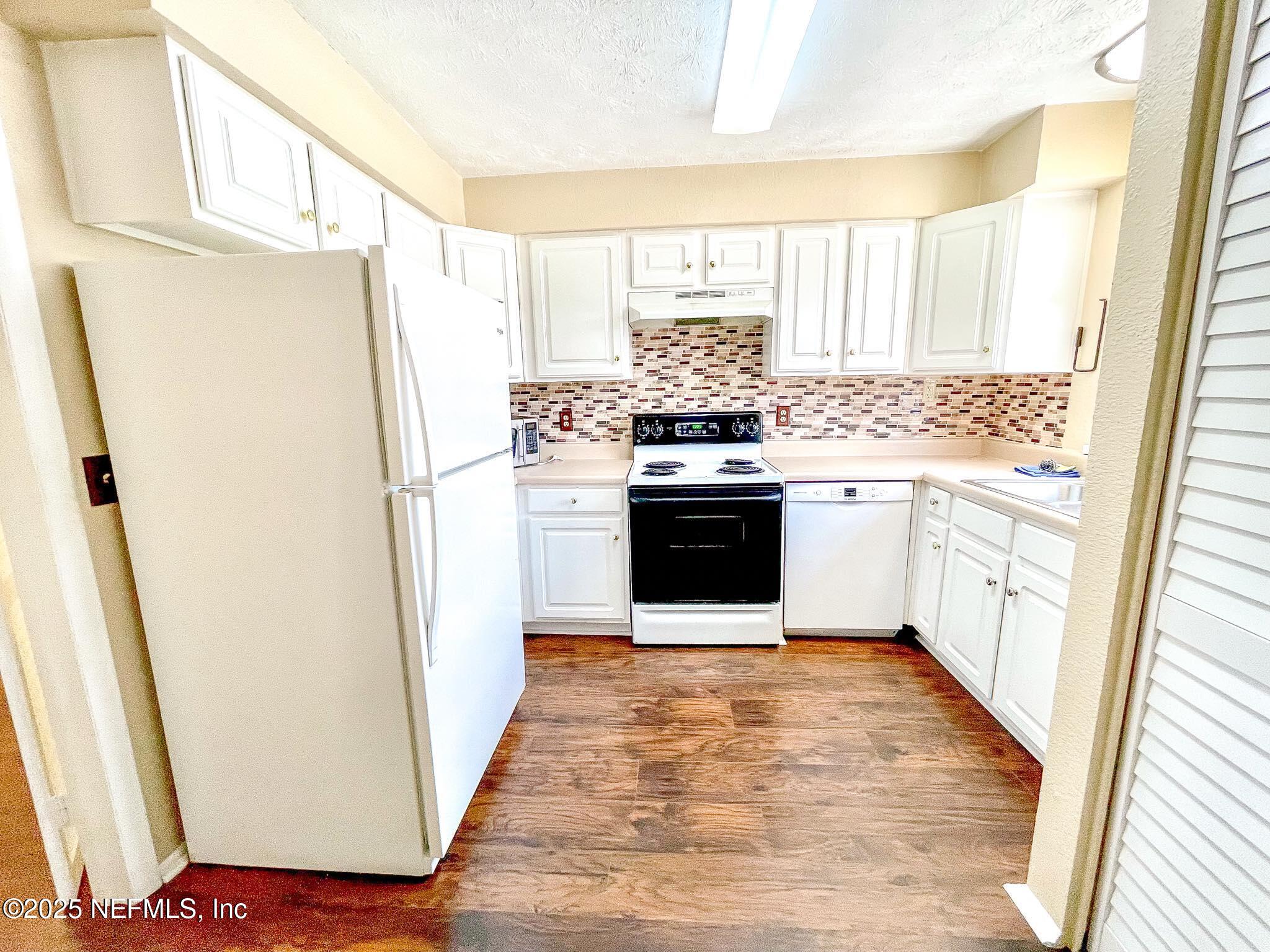 4915 Baymeadows Road, Unit 13D Jacksonville, FL 32217 - Photo 20 of 23 a kitchen with a refrigerator a stove a sink and a window