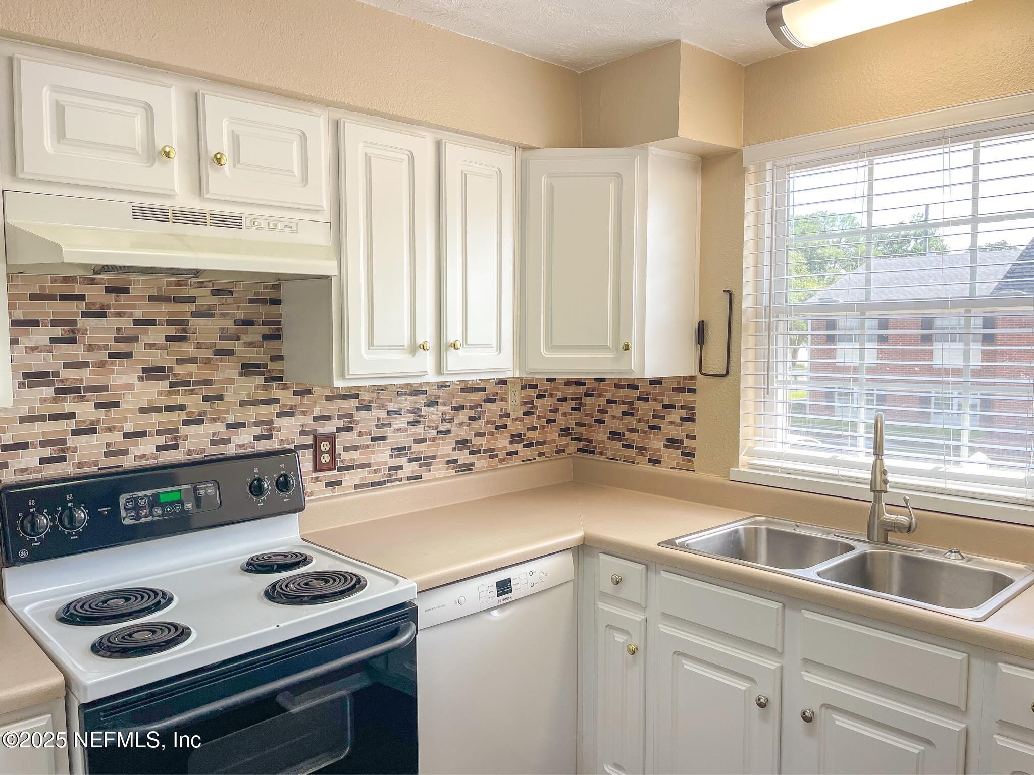 4915 Baymeadows Road, Unit 13D Jacksonville, FL 32217 - Photo 21 of 23 a kitchen with granite countertop a sink stove and cabinets