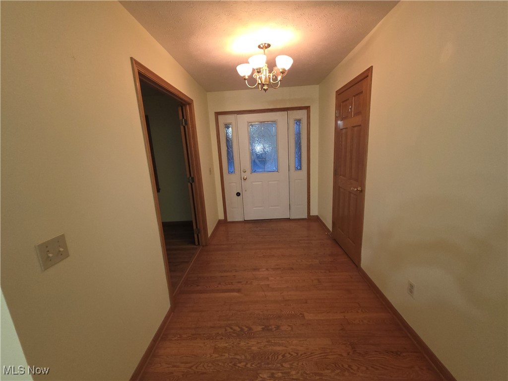 2291 Armstrong Road Wooster, OH 44691 - Photo 2 of 23 Doorway with wood finished floors, suspended lighting, and a textured ceiling