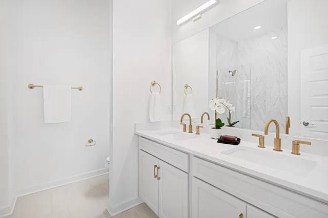 a bathroom with a sink and mirror with shower