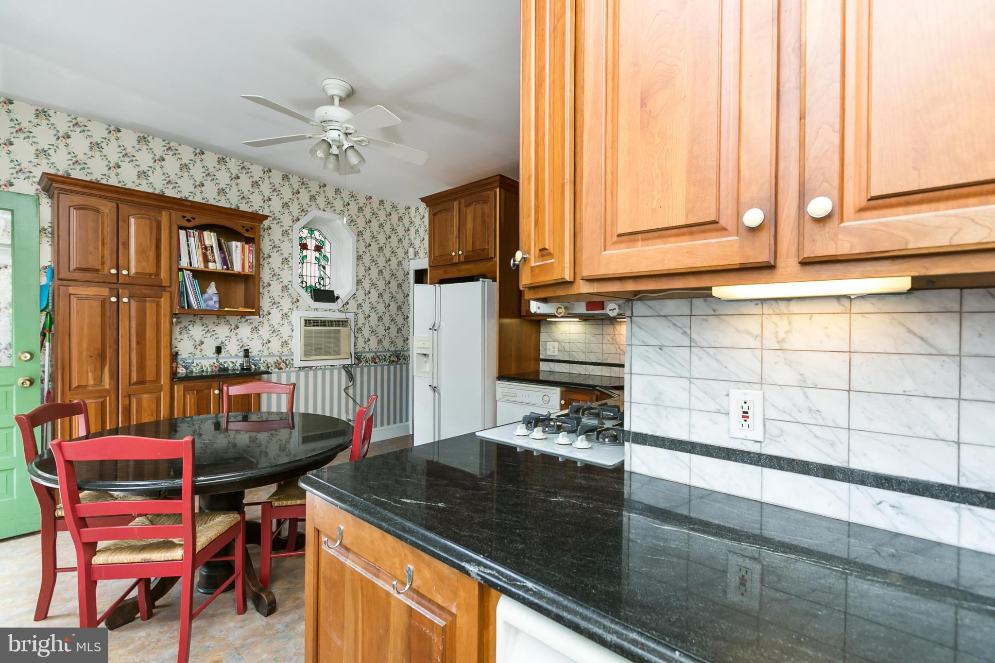 4015 Roland Avenue Baltimore, MD 21211 - Photo 11 of 30 a kitchen with a stove a table and chairs in it